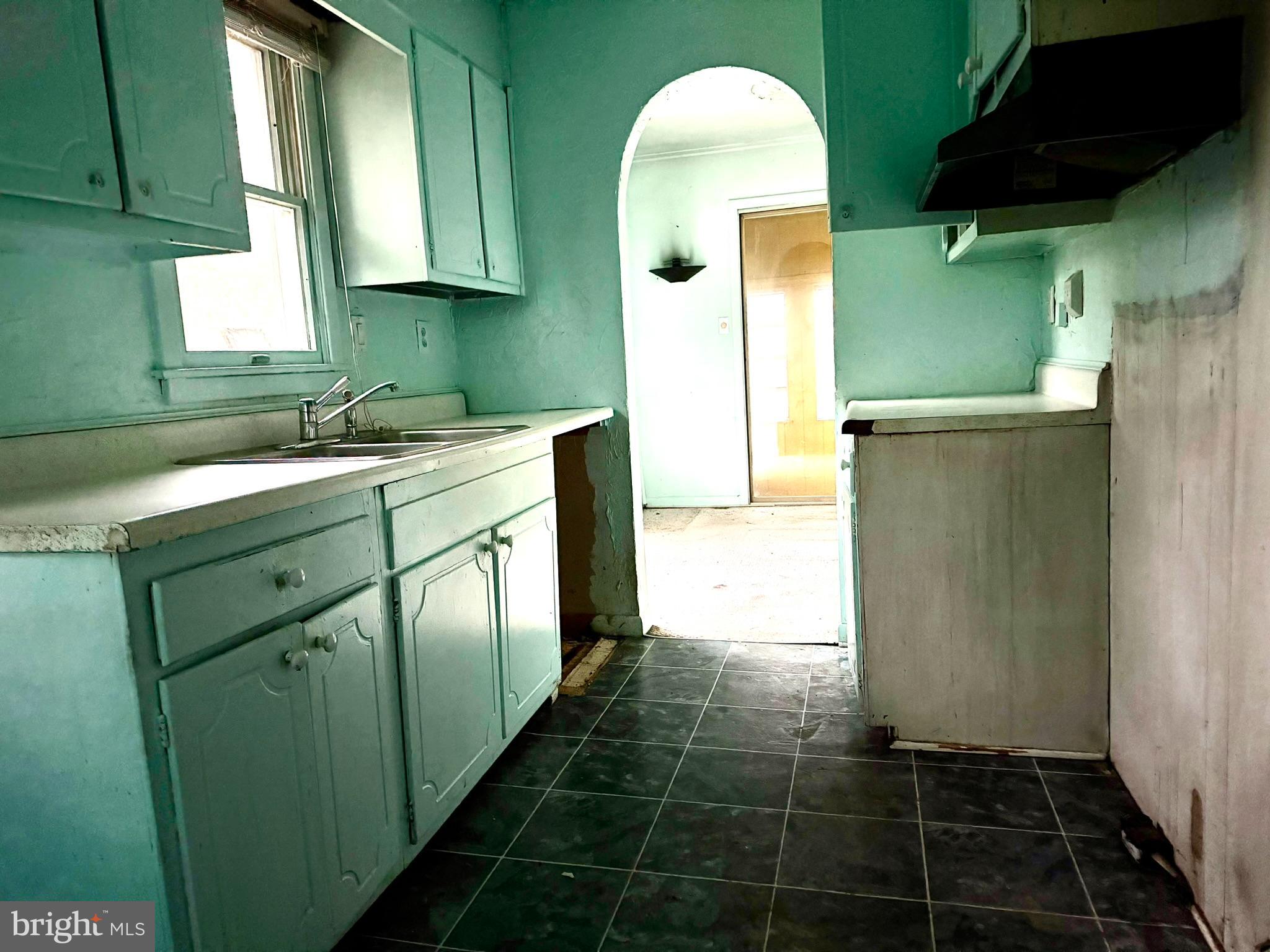 112 Strawberry Way Rehoboth Beach, DE 19971 - Photo 7 of 14 a kitchen with a sink a refrigerator and cabinets