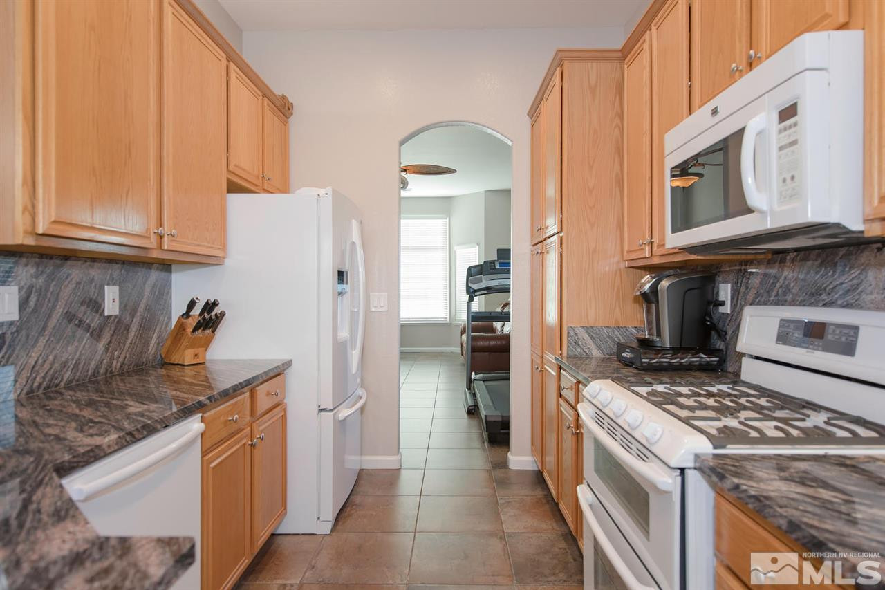 1184 University Ridge Drive Reno, NV 89512 - Photo 8 of 25 a kitchen with stainless steel appliances granite countertop a stove and a refrigerator