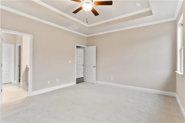 an empty room with a ceiling fan and carpet