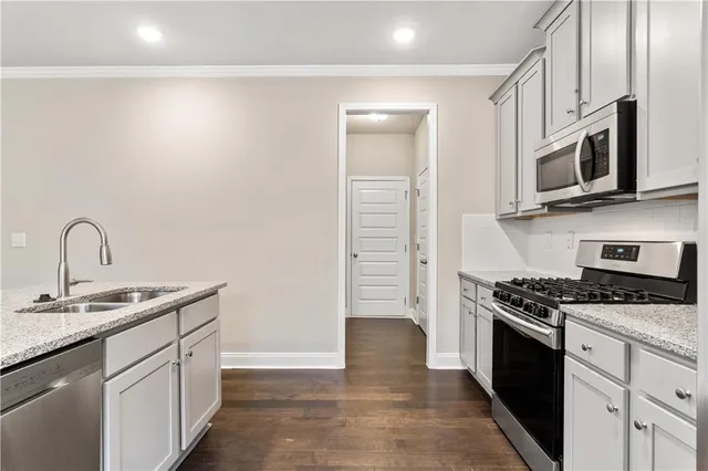 a kitchen with stainless steel appliances granite countertop a sink and a stove
