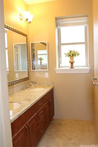 a bathroom with a granite countertop sink mirror and a window