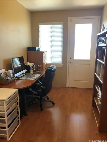 a view of a workspace with furniture and a window