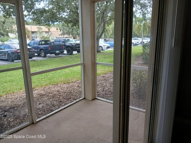 a view of a porch with a big yard and potted plants