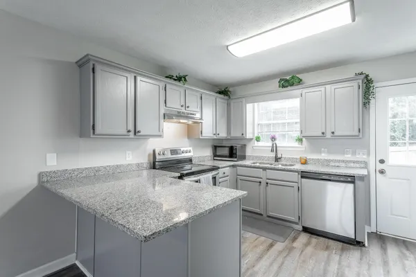 a kitchen with stainless steel appliances granite countertop a sink stove and cabinets