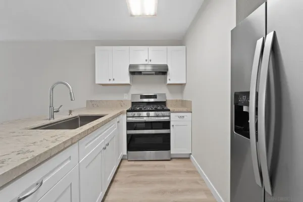 a kitchen with stainless steel appliances granite countertop a stove and a refrigerator
