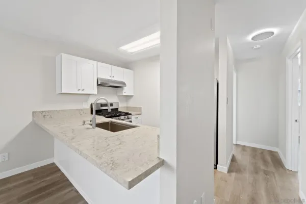 a kitchen with granite countertop a sink stove and cabinets