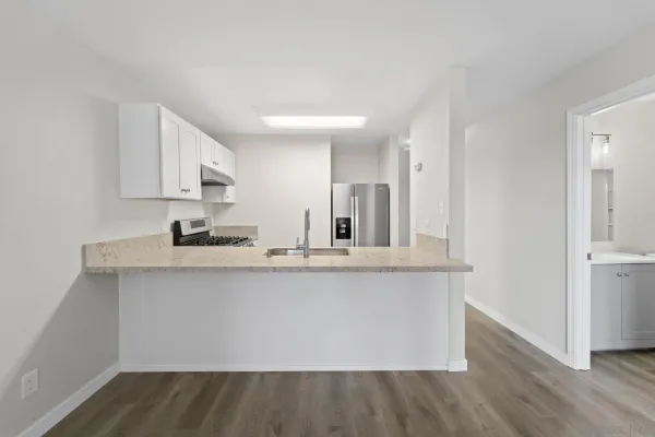 a large white kitchen with wooden floor