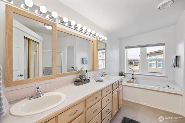 a bathroom with a double vanity sink and mirror with shower