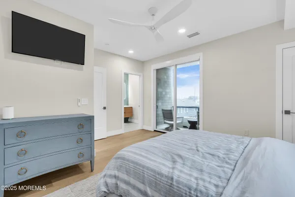 a spacious bedroom with a bed and a flat screen tv