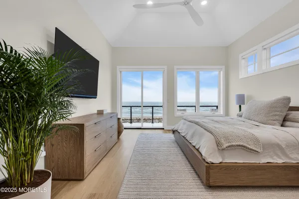 a spacious bedroom with a large bed and a flat tv screen on dresser