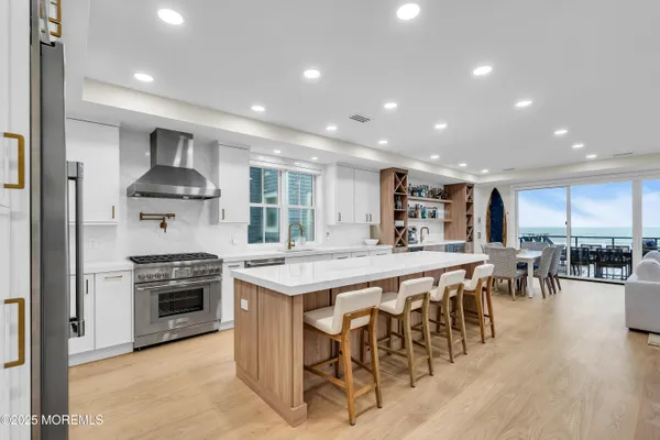 a kitchen with stainless steel appliances granite countertop table chairs stove and cabinets