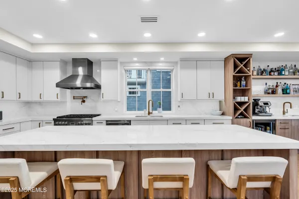 a kitchen with stainless steel appliances granite countertop a table chairs sink and cabinets