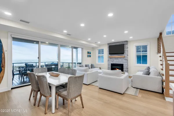 a living room with furniture a fireplace and a dining table with wooden floor