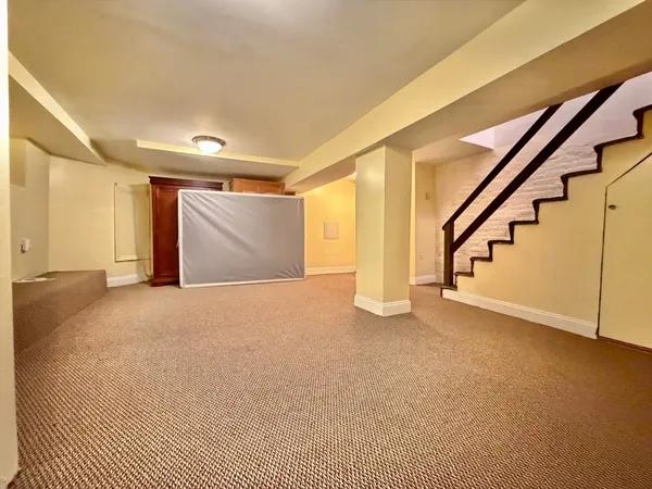 a view of an empty room with stairs and a window