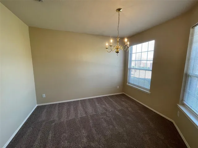 en empty room with windows and chandelier