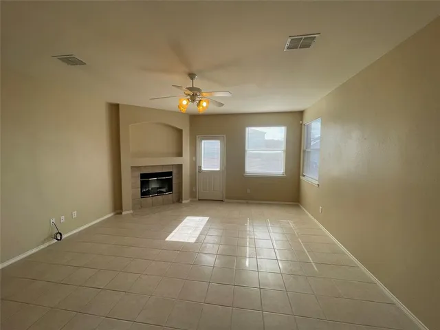 a view of an empty room with a fireplace and a window