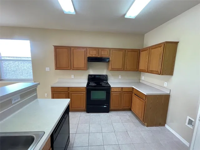 a kitchen with a stove top oven sink and cabinets