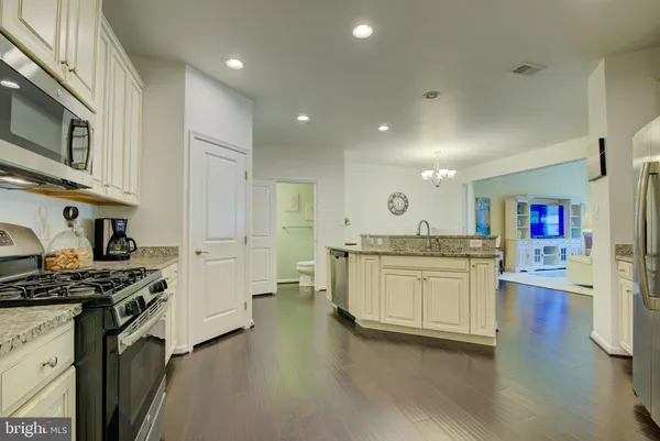 a open kitchen with stainless steel appliances granite countertop a stove and a sink