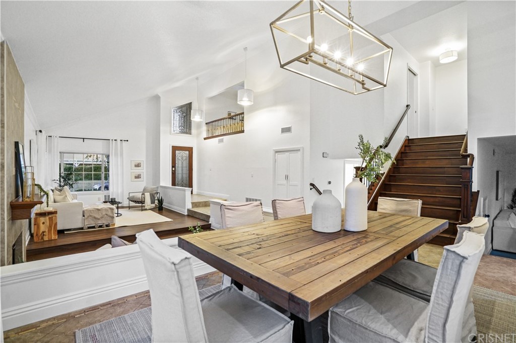 24609 Skyridge Drive Newhall, CA 91321 - Photo 1 of 60 a dining room with wooden floor a chandelier a wooden table and chairs