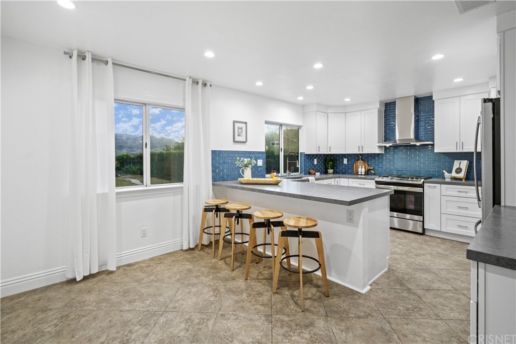 24609 Skyridge Drive Newhall, CA 91321 - Photo 12 of 60 a kitchen with stainless steel appliances granite countertop a table chairs sink refrigerator and cabinets