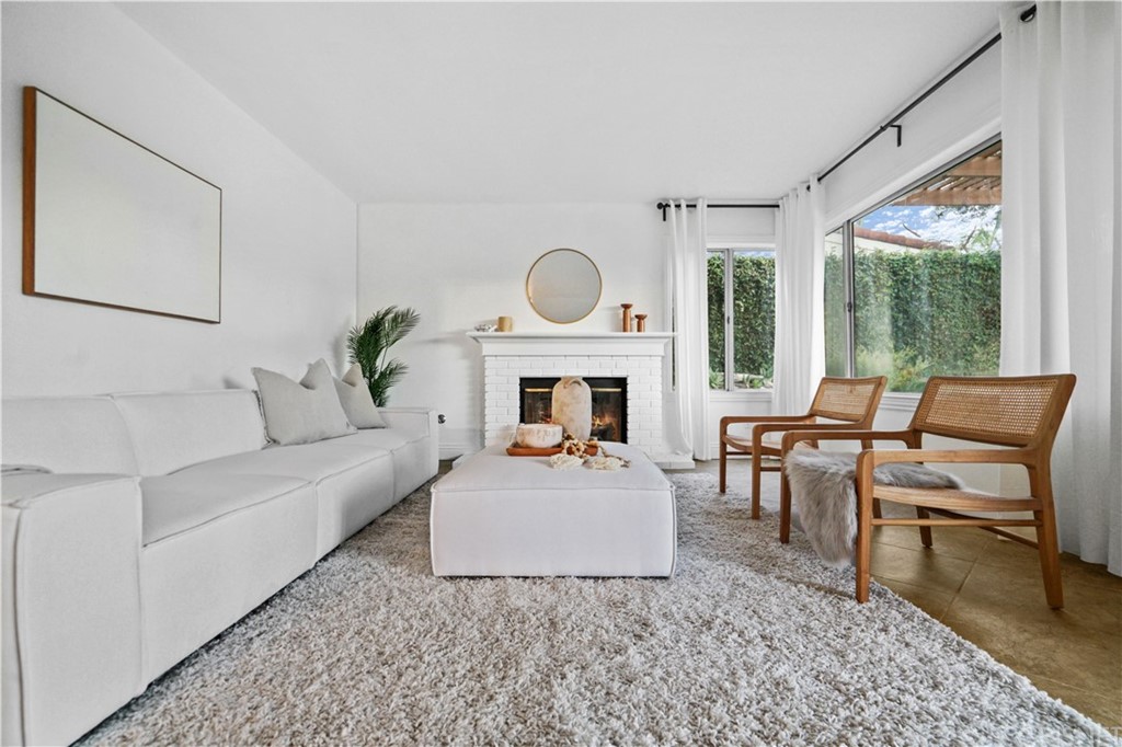 24609 Skyridge Drive Newhall, CA 91321 - Photo 16 of 60 a living room with furniture a fireplace and a table
