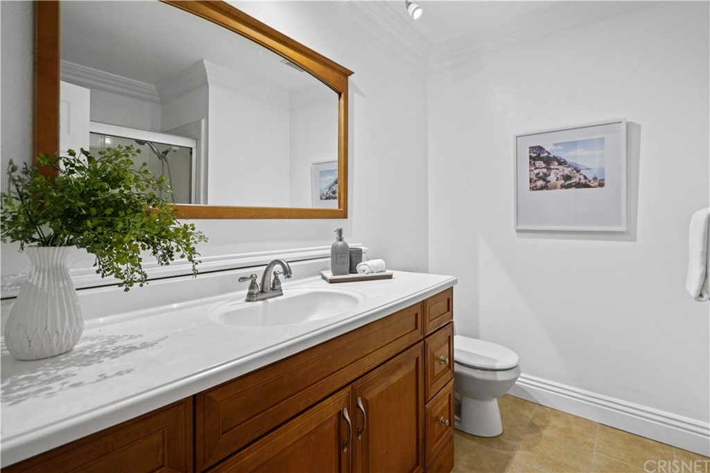 24609 Skyridge Drive Newhall, CA 91321 - Photo 31 of 60 a bathroom with a granite countertop sink a toilet and a mirror