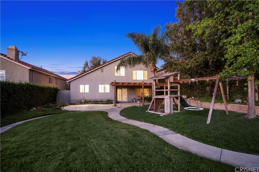 24609 Skyridge Drive Newhall, CA 91321 - Photo 36 of 60 a view of a house with a yard fire pit and a large tree
