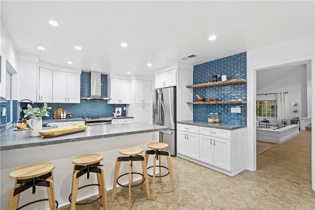 24609 Skyridge Drive Newhall, CA 91321 - Photo 10 of 60 a kitchen with stainless steel appliances a stove a sink and a refrigerator