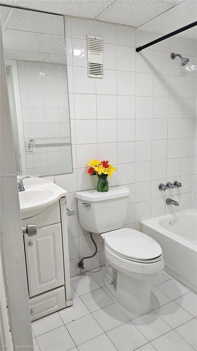 10641 Southwest 108th Avenue, Unit 1H Miami, FL 33176 - Photo 19 of 22 a white toilet sitting next to a bathroom sink and a shower