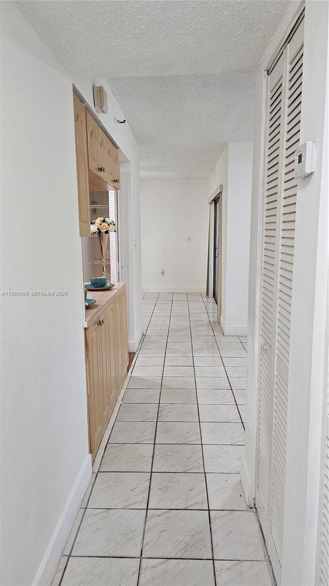 10641 Southwest 108th Avenue, Unit 1H Miami, FL 33176 - Photo 6 of 22 a hallway with white walls and tiles
