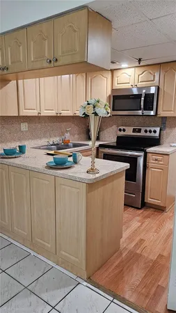 a kitchen with kitchen island granite countertop a sink cabinets and stainless steel appliances