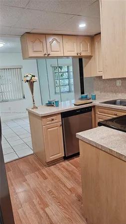 a kitchen with stainless steel appliances granite countertop a sink a stove and a wooden floors