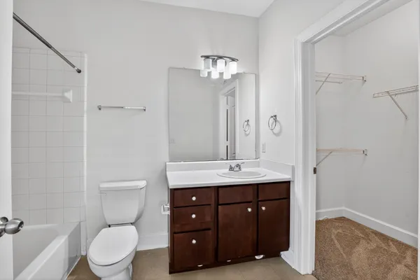 a spacious bathroom with a toilet a sink and a mirror