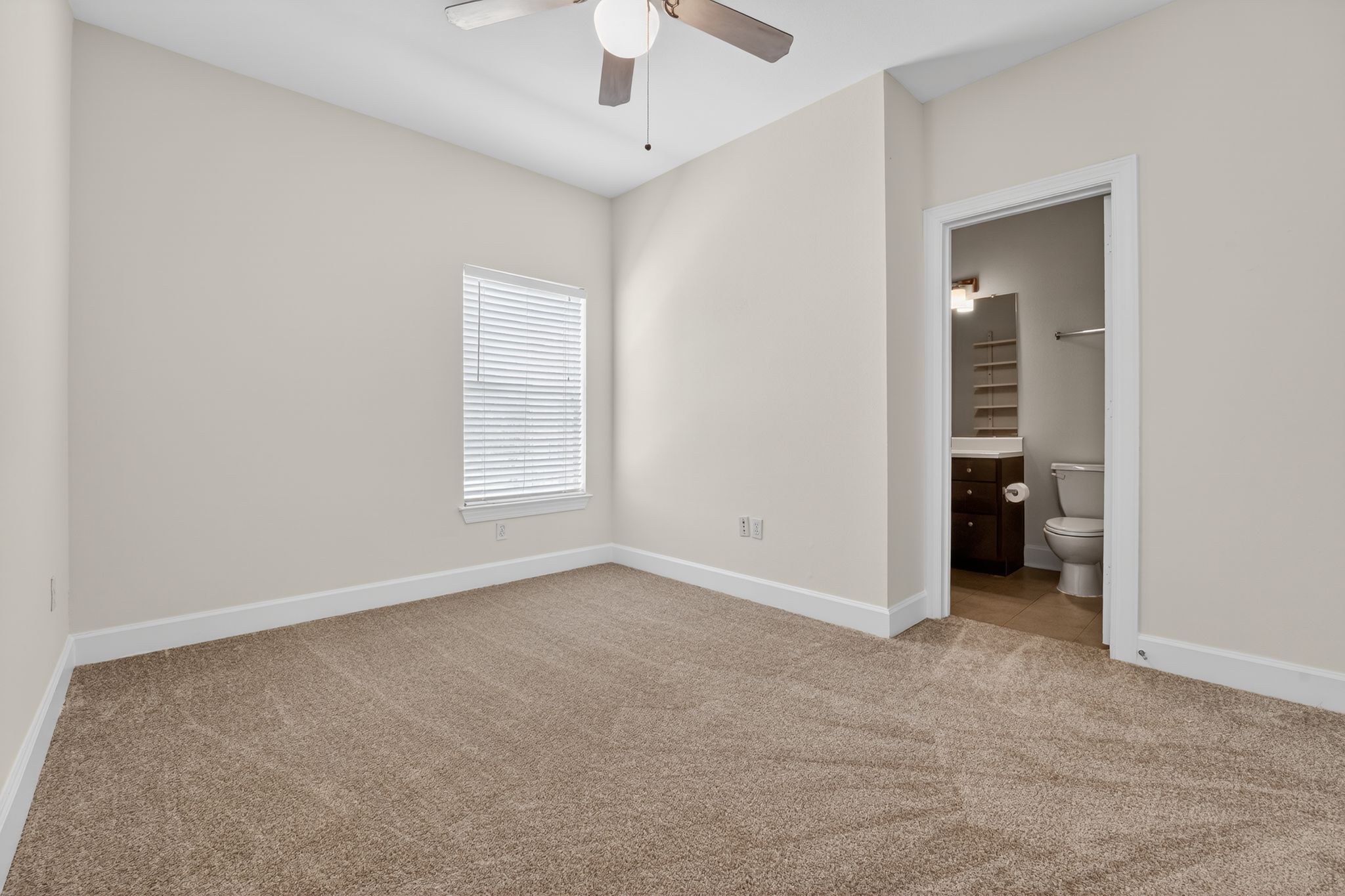 1901 Crossing Place, Unit 2201A Austin, TX 78741 - Photo 8 of 23 an empty room with a ceiling fan and a window