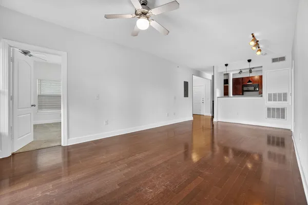 a view of a livingroom with wooden floor and a ceiling fan