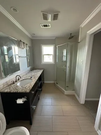 a bathroom with a granite countertop sink a toilet a mirror and vanity
