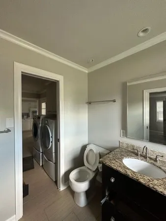 a bathroom with a granite countertop sink a toilet and a mirror