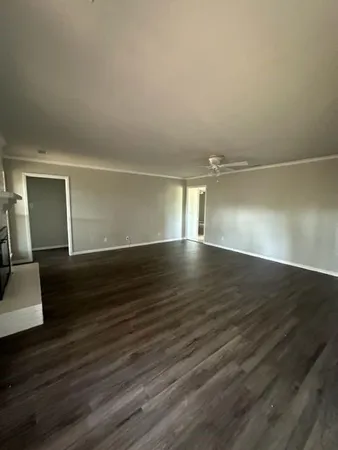 a view of empty room with wooden floor