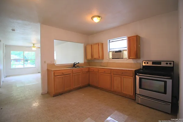 a kitchen with granite countertop a stove a sink and a microwave