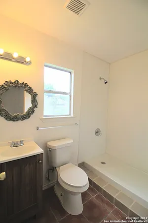 a bathroom with a toilet a sink and a mirror