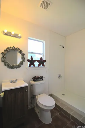 a bathroom with a sink mirror vanity and toilet