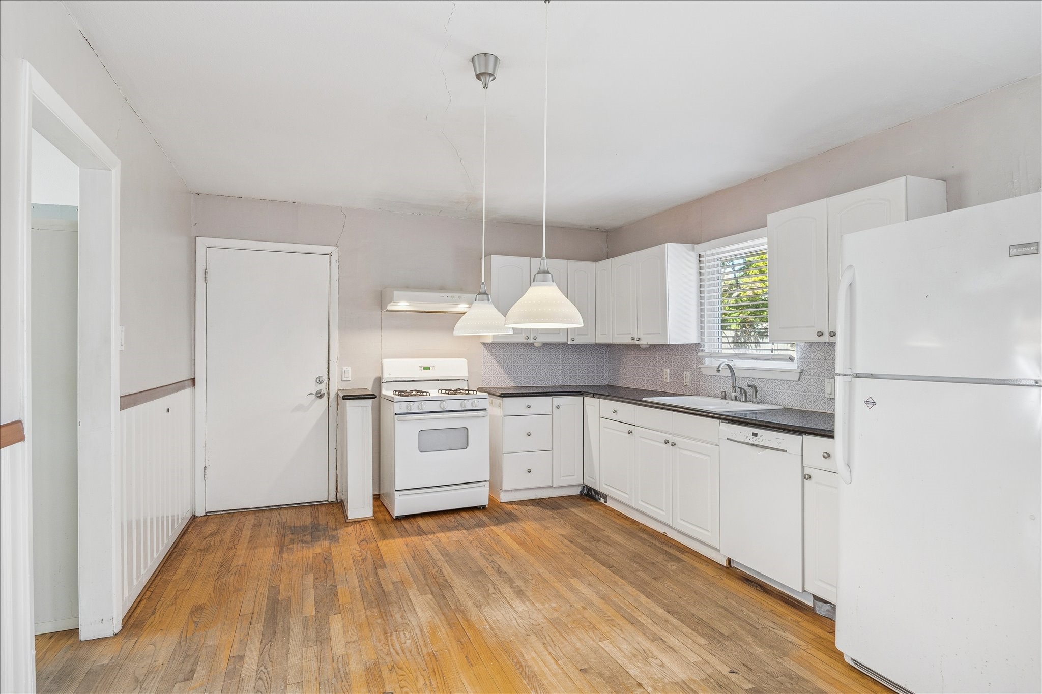 8419 Bluegate Court Houston, TX 77025 - Photo 4 of 12 a kitchen with white cabinets and white appliances