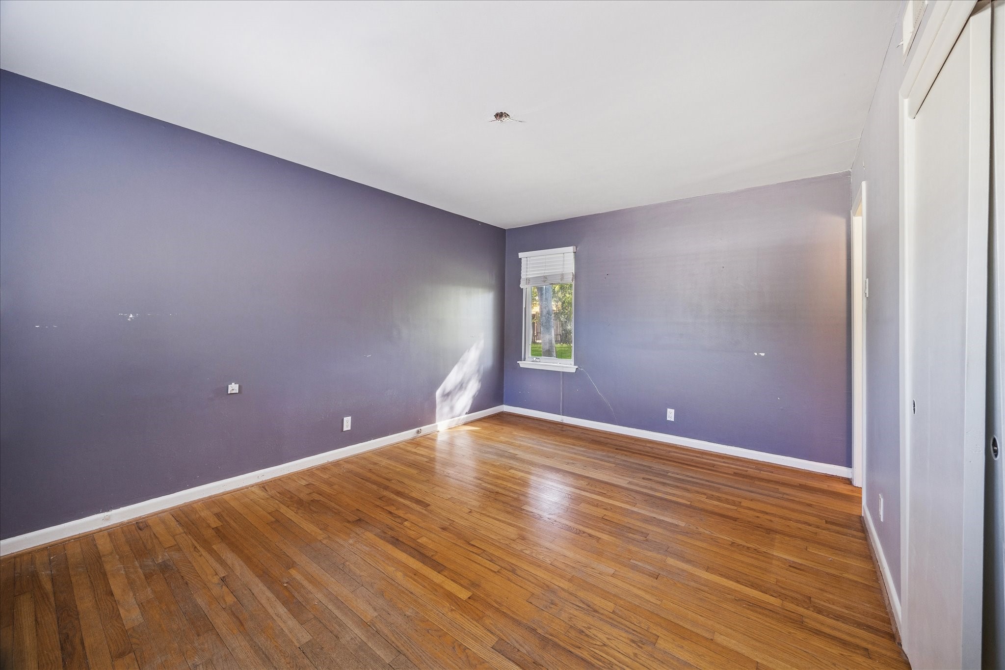 8419 Bluegate Court Houston, TX 77025 - Photo 7 of 12 a view of an empty room with wooden floor and a window