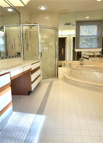 a spacious bathroom with a tub shower and sink