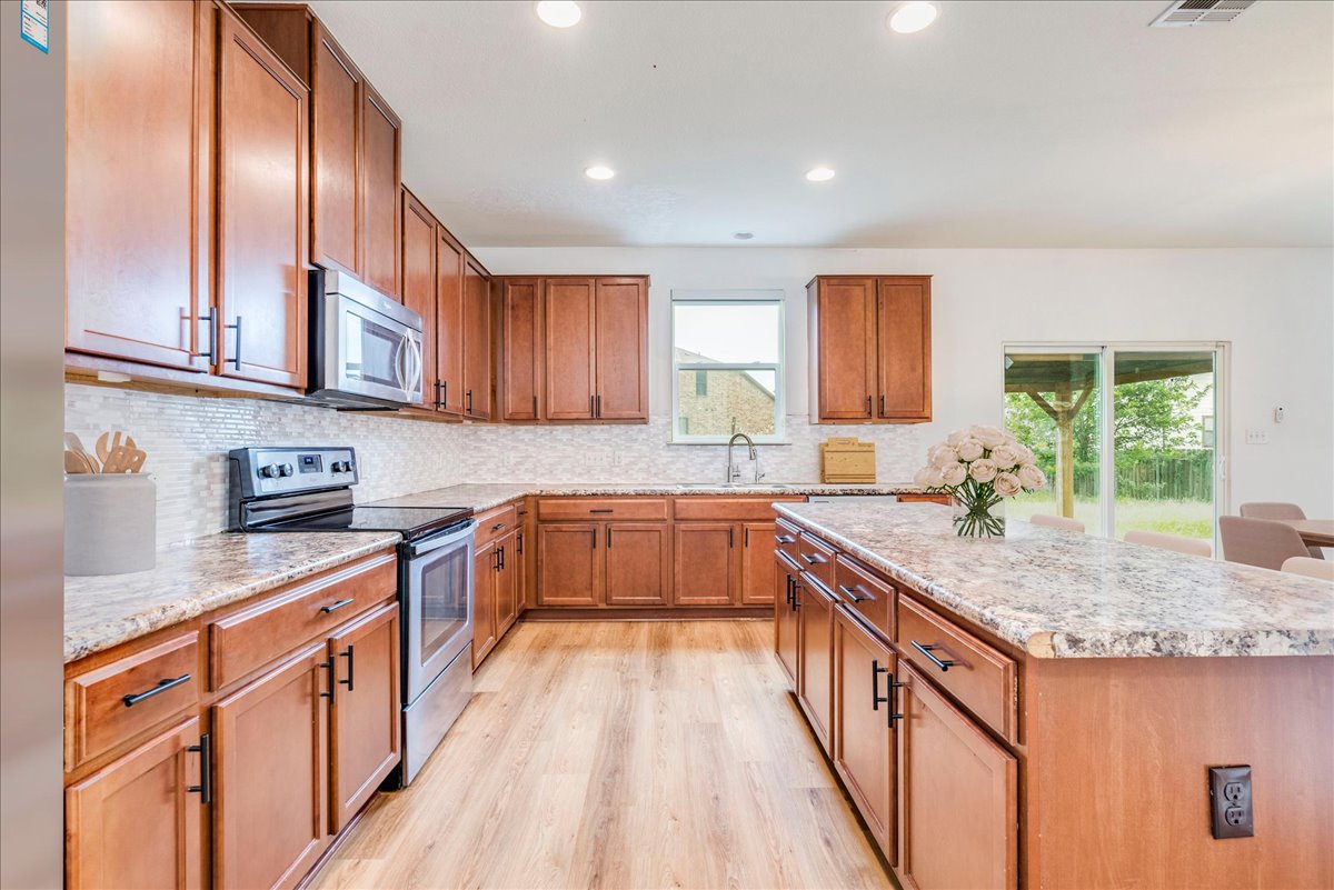 401 Waterleaf Boulevard Kyle, TX 78640 - Photo 11 of 28 Kitchen with wood cabinets, stainless steel appliances, and new backsplash