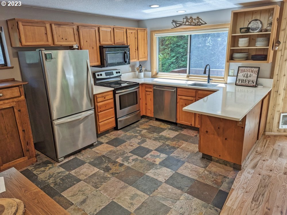 28513 Road 20 Rhododendron, OR 97049 - Photo 25 of 38 a kitchen with stainless steel appliances granite countertop a refrigerator stove top oven and sink
