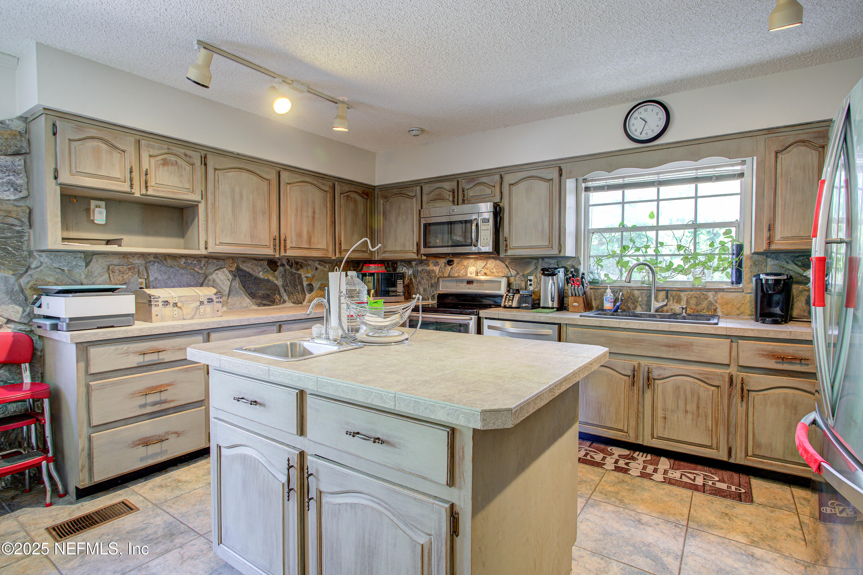 4302 Buck Point Road Jacksonville, FL 32210 - Photo 30 of 74 a kitchen with a stove a sink a refrigerator and cabinets