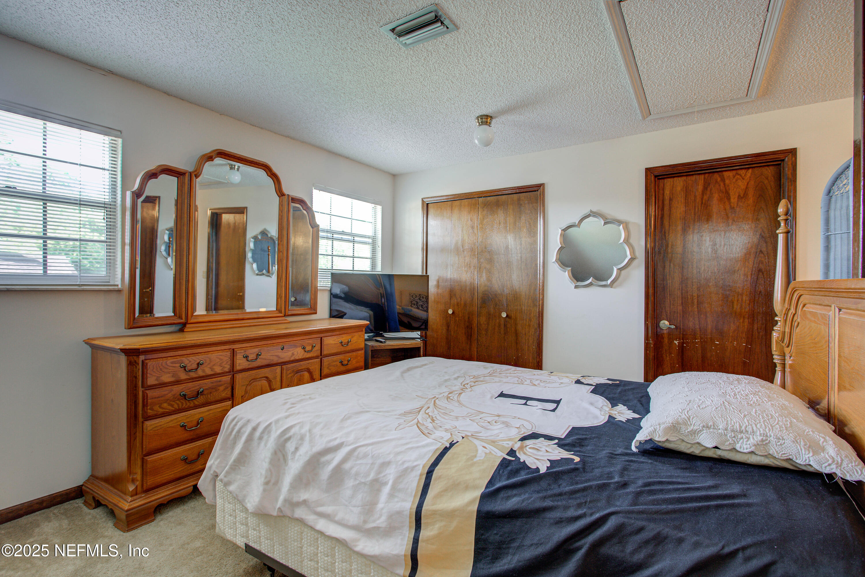 4302 Buck Point Road Jacksonville, FL 32210 - Photo 58 of 74 a bedroom with a large bed and a chandelier