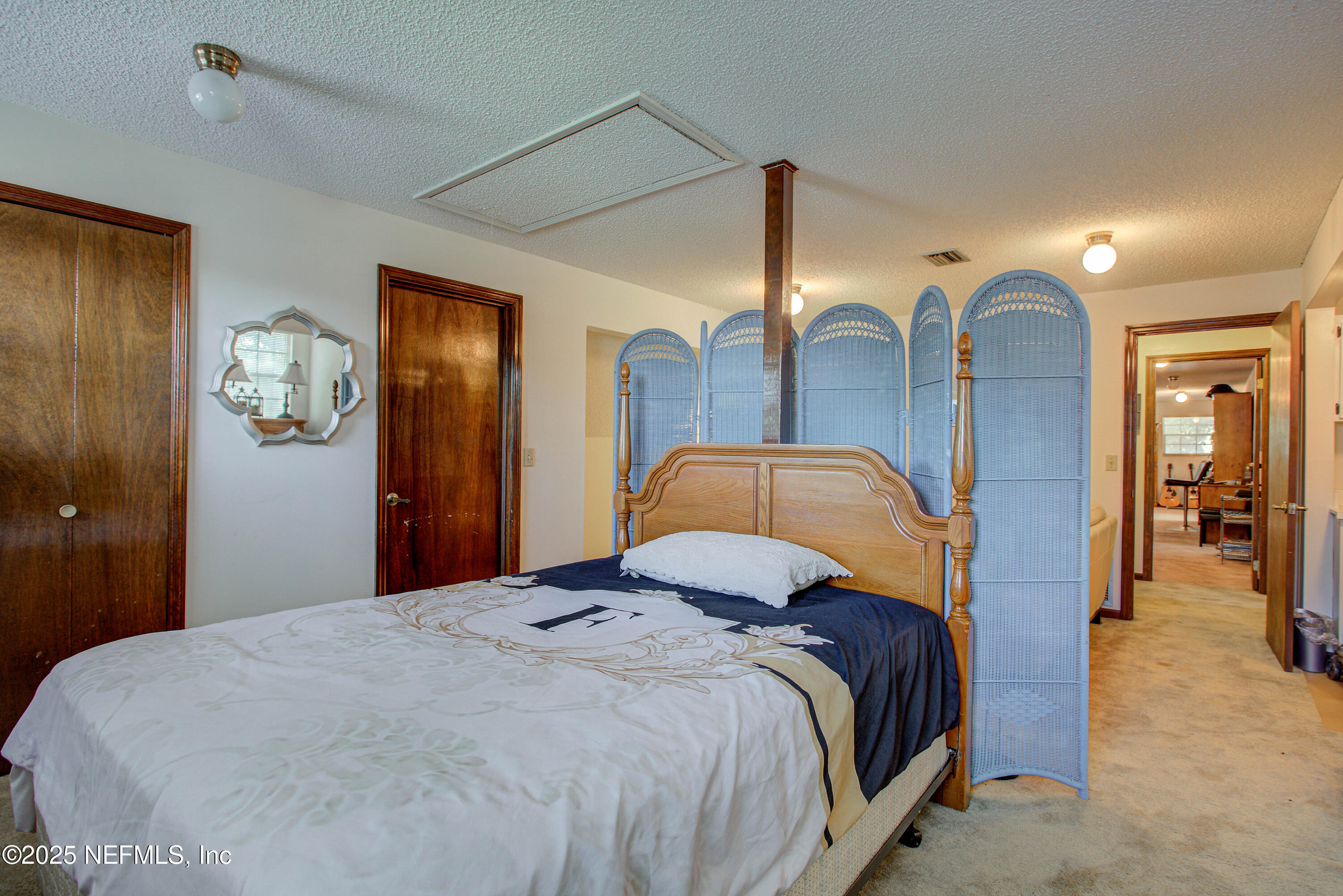 4302 Buck Point Road Jacksonville, FL 32210 - Photo 59 of 74 a bedroom with a bed and lamp with mirror