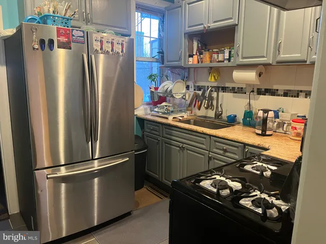 a kitchen with stainless steel appliances granite countertop a refrigerator and a stove